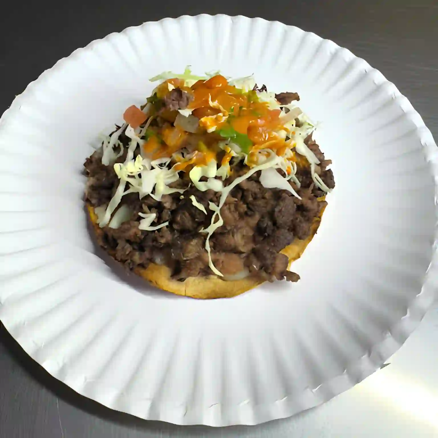 Lorenza - Crispy corn tortilla with grilled meat, melted cheese, and salsa